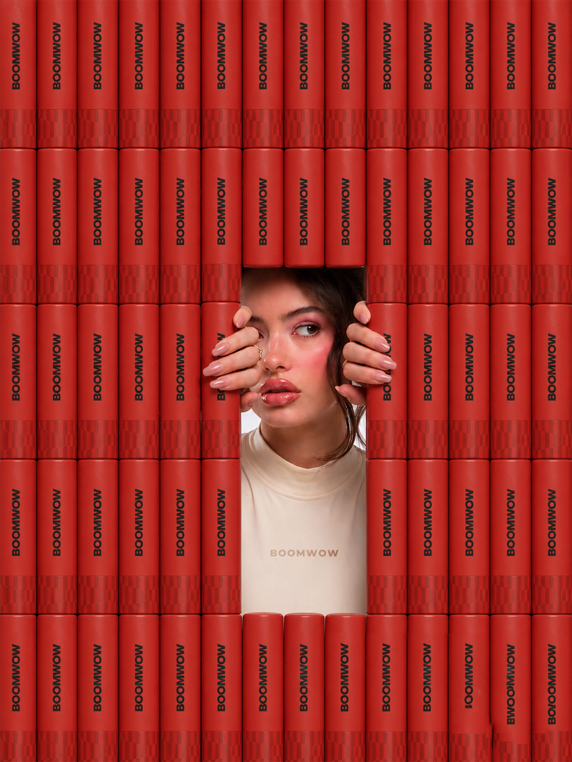 A wall of red BOOMWOW confetti poppers framing a joyful portrait