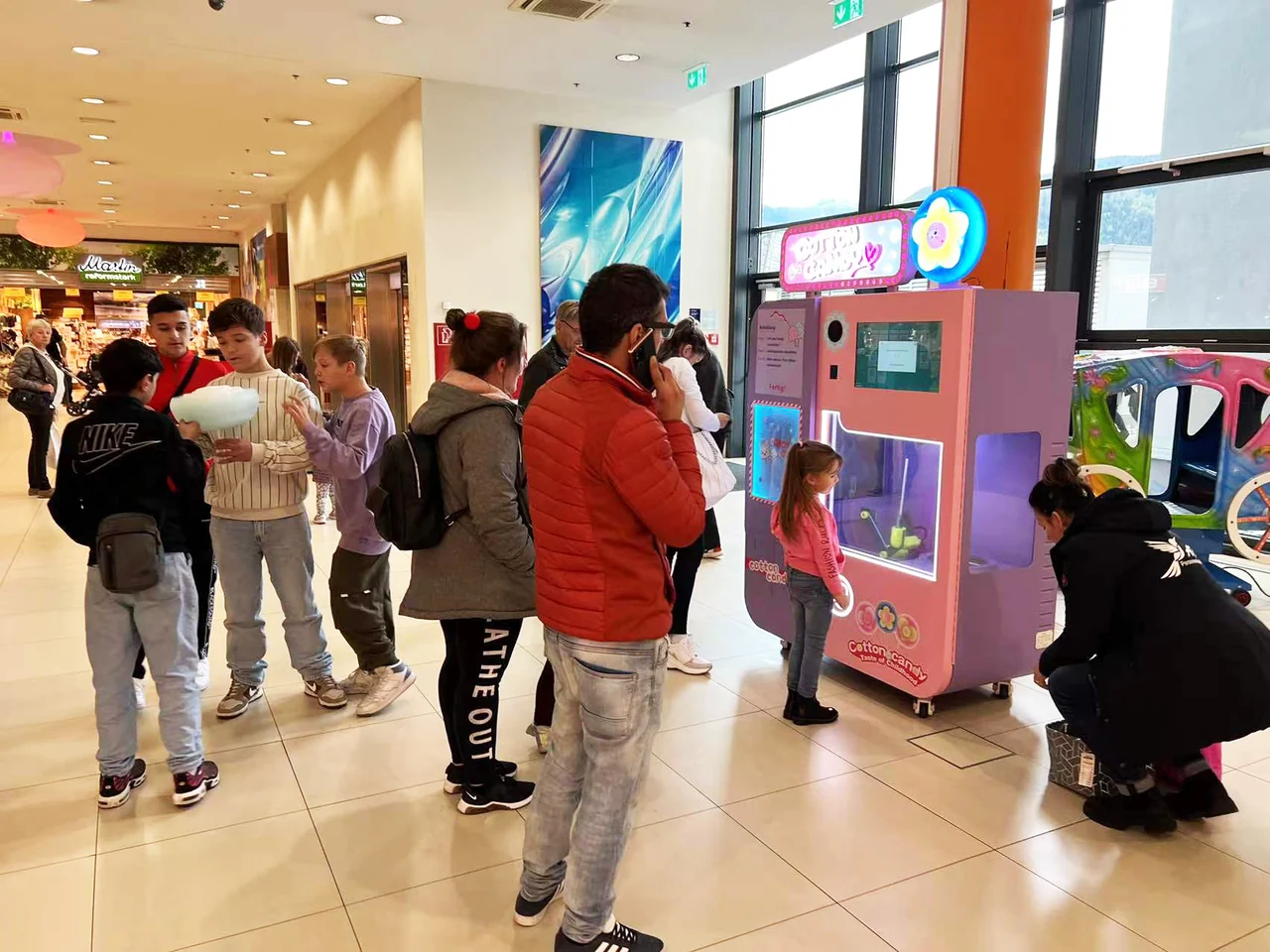 Cotton candy vending machine in a busy theme park venue